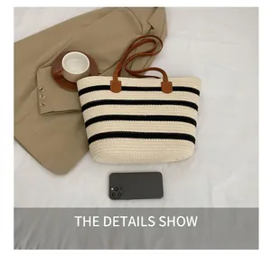 Detail view of woven cotton tote bag with striped pattern and brown leather handles