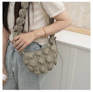 Detail of light grey-green quilted cloud bag with pleated texture and wide bubble strap