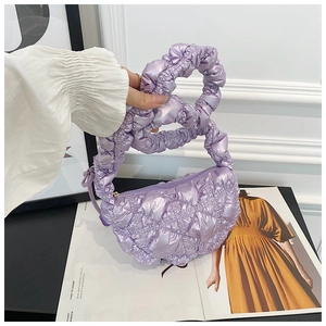 Close-up of light purple pleated cloud bag with shiny quilted texture and soft handle