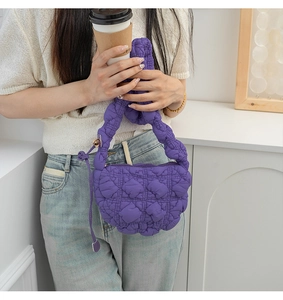 Detail of purple quilted puffer cloud bag with plush nylon texture and zipper charm