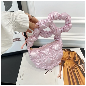 Detail of pink quilted cloud bag with padded ruffled handle and glossy finish