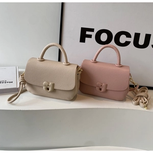 Détail de sacs selle en cuir grainé beige et rose avec boucles géométriques élégantes