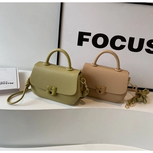 Détail rapproché des sacs en cuir grainé avec d'élégantes boucles métalliques en forme de U