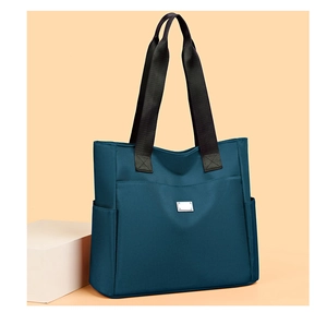 Detailansicht einer dunkelblauen Oxford-Stofftasche mit breiten Trägern und Metallverzierung