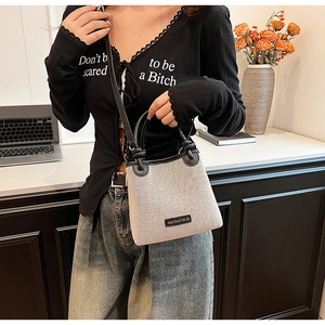 Detail of minimalist straw tote bag with black leather trim and woven fabric texture
