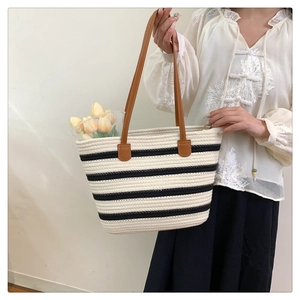 Detail of woven cotton rope tote with black and white stripes and leather handles