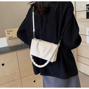 Detail of off-white ruched cloud bag with wide pleated handle and silver hardware