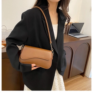 Gros plan d'un sac porté épaule en simili cuir caramel avec bandoulière réglable dorée