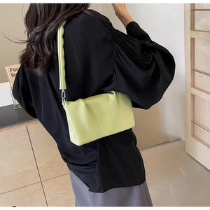 Close-up of light green pleated shoulder bag showing soft leather texture and drape