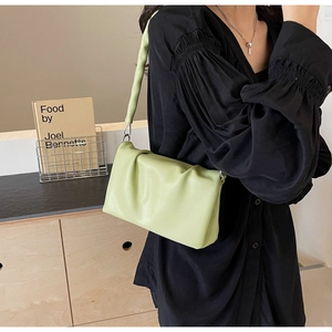 Fashionable light green ruched baguette bag with chunky handle shown in lifestyle setting