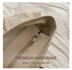 Detailed macro view of the smooth metal zipper and inner lining of a straw tote bag