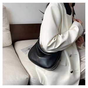 Detailed view of black PU leather hobo bag with sleek moon shape and wide shoulder strap