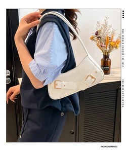 Detail of white crescent shoulder bag with golden buckles on textured PU leather