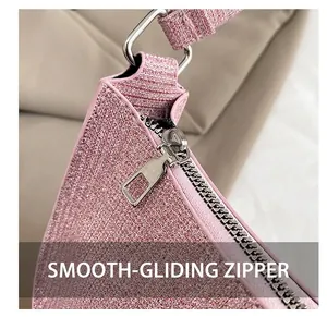 Detail of silver metal zipper and D-ring on pink glitter bag with smooth finish