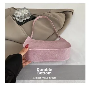 Detail showing the wear-resistant reinforced bottom of the pink glitter shoulder bag