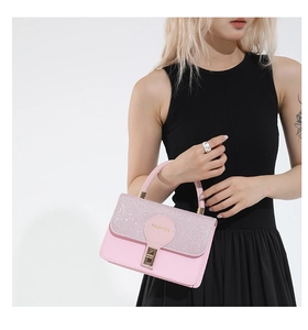 Detail of pink fashion handbag with sparkling glitter flap and gold metal lock buckle