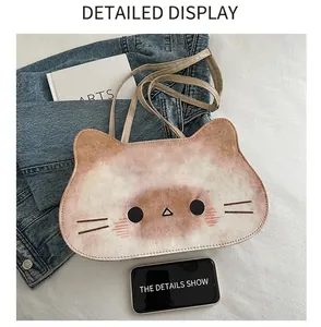 Detail view of the cute cat-shaped crossbody bag shown next to a smartphone for size reference