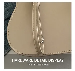 Macro shot of silver D-ring hardware and precise stitching on the cream leather tote bag