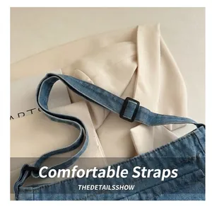 Close-up of adjustable strap on blue denim bag with buckle and neat stitching