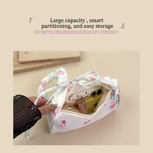 Spacious floral handbag with drawstring bow handle holding a phone and cosmetics