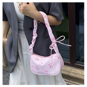 Detailed view of pink floral satchel featuring pleated cloud strap and ribbon details