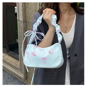 Detail of light blue hobo bag with pink rose patterns and pleated handle strap