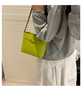 Détail du sac seau vert néon avec boucle métallique décorative et longue bandoulière réglable