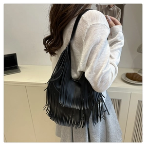 Primer plano de un bolso tote de cuero mate negro con flecos largos de estilo bohemio