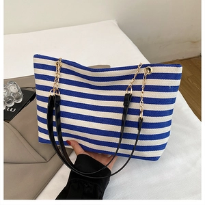 Detailed close-up of blue and white striped tote bag showing woven texture and chain strap