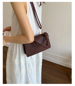 Vue détaillée de la texture tissée marron foncé et du rabat de ce sac à bandoulière
