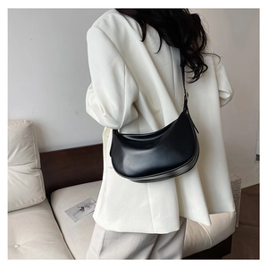 Detail of minimalist black PU hobo bag with a soft matte texture on a shoulder strap