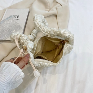 Glossy cream pleated cloud bag with soft nylon texture and interior storage pocket