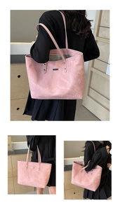 Detail of pink faux suede tote bag featuring reinforced rivets and a metal logo plaque