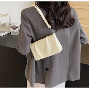 Gros plan sur le sac nuage blanc plissé avec texture en cuir souple sur un mannequin
