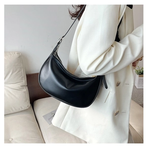 Detail of adjustable strap and silver hardware on a black PU leather hobo bag