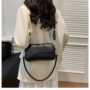 Vue de dos d'un mannequin portant un sac besace noir avec une chaîne en métal doré