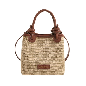 Chic beige straw bucket bag with dark brown leather trim and dual handles for women