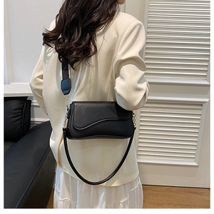 Vue mannequin d'un sac besace noir avec large bandoulière en tissu et boucles dorées