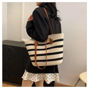 Detail of hand-woven striped cotton tote bag with premium brown leather handles