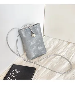 Detail of grey fabric phone bag with silver texture, pearl buckle and thin cord strap