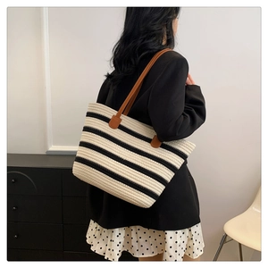 Detail of woven cotton tote with black and white stripes and brown leather handles