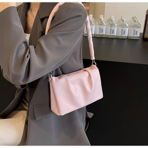 Detail of light pink pleated cloud bag with soft PU leather texture and silver metal rings
