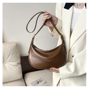 Detailed view of dark brown PU hobo bag with adjustable strap held by a model