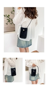 Detail of mini black suede crossbody phone bag featuring a large pearl button closure