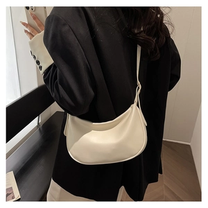Minimalist cream PU crescent bag worn with a black blazer for a stylish contrast look