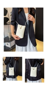 Detail view of a cream white mini crossbody bag with an elegant large pearl closure