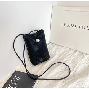 Detail of black suede crossbody phone bag with pearl clasp and thin rope strap