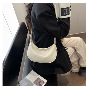 Chic cream white crescent bag shown styled on a model's shoulder for a minimalist look