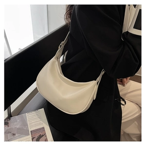 Detailed close-up of a minimalist cream-colored hobo bag featuring premium matte PU leather