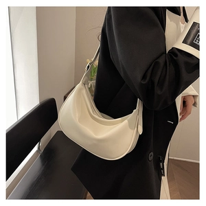 Detail of cream white PU crescent shoulder bag showing sleek texture and drape